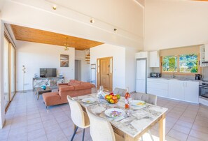 A modern apartment with a dining area, kitchen, and living room. - Villa Kochili - Two Bedroom Villa, Sleeps 4 (Nea Dimmata)