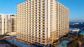 Un hôtel de grande hauteur doté de nombreux balcons, d’une piscine et d’un espace paysager.
