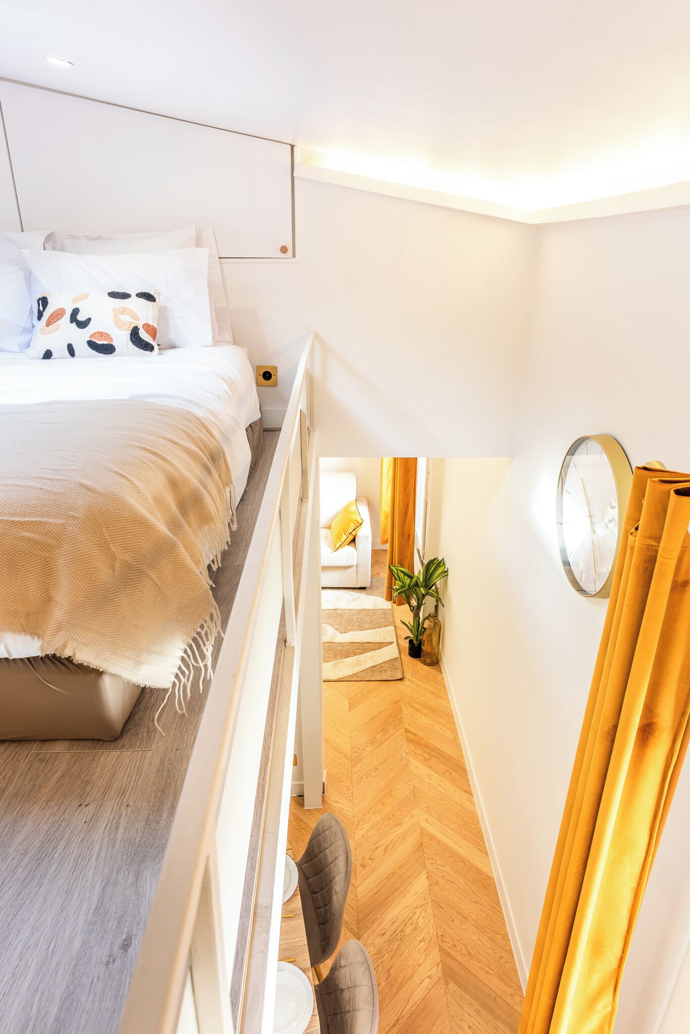 A modern bedroom with a bed, bedside table, and a view of the hallway.