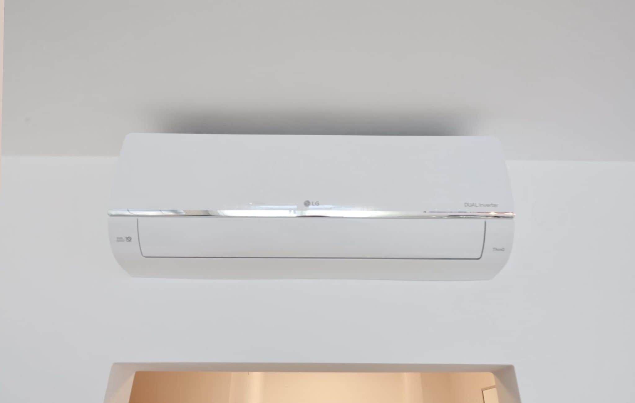 A white air conditioning unit mounted on a ceiling.