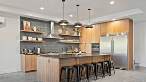 Una cucina moderna con isola centrale, elettrodomestici in acciaio inossidabile e mobili in legno.