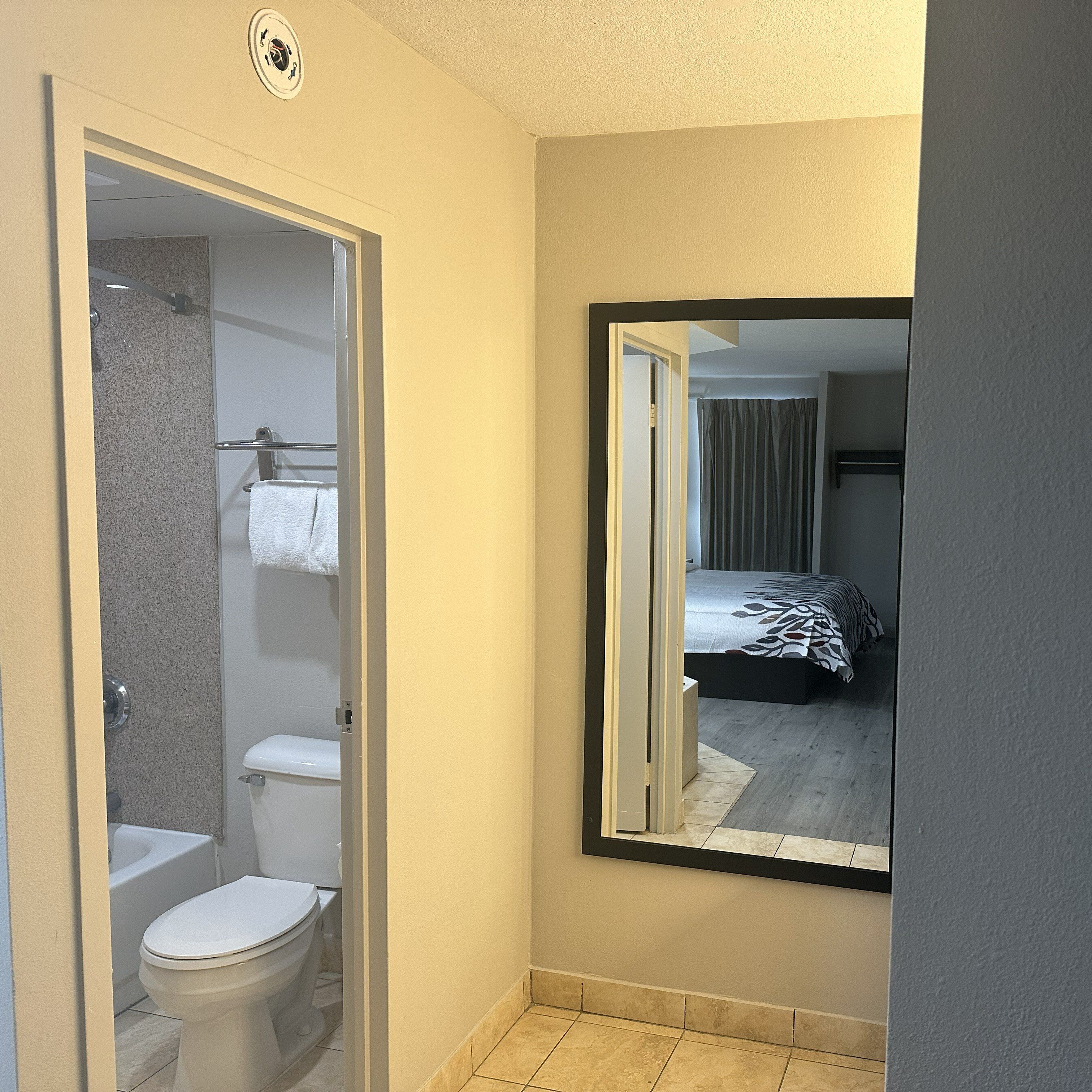 Une salle de bain équipée de toilettes, d’une douche et d’un porte-serviettes.