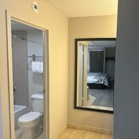 Un baño con inodoro, ducha y toallero.