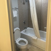 Un baño con inodoro, bañera y cortina de ducha.
