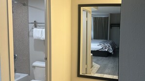 A bathroom with a toilet, a shower, and a towel rack. - Red Roof Inn Media, PA (Media)