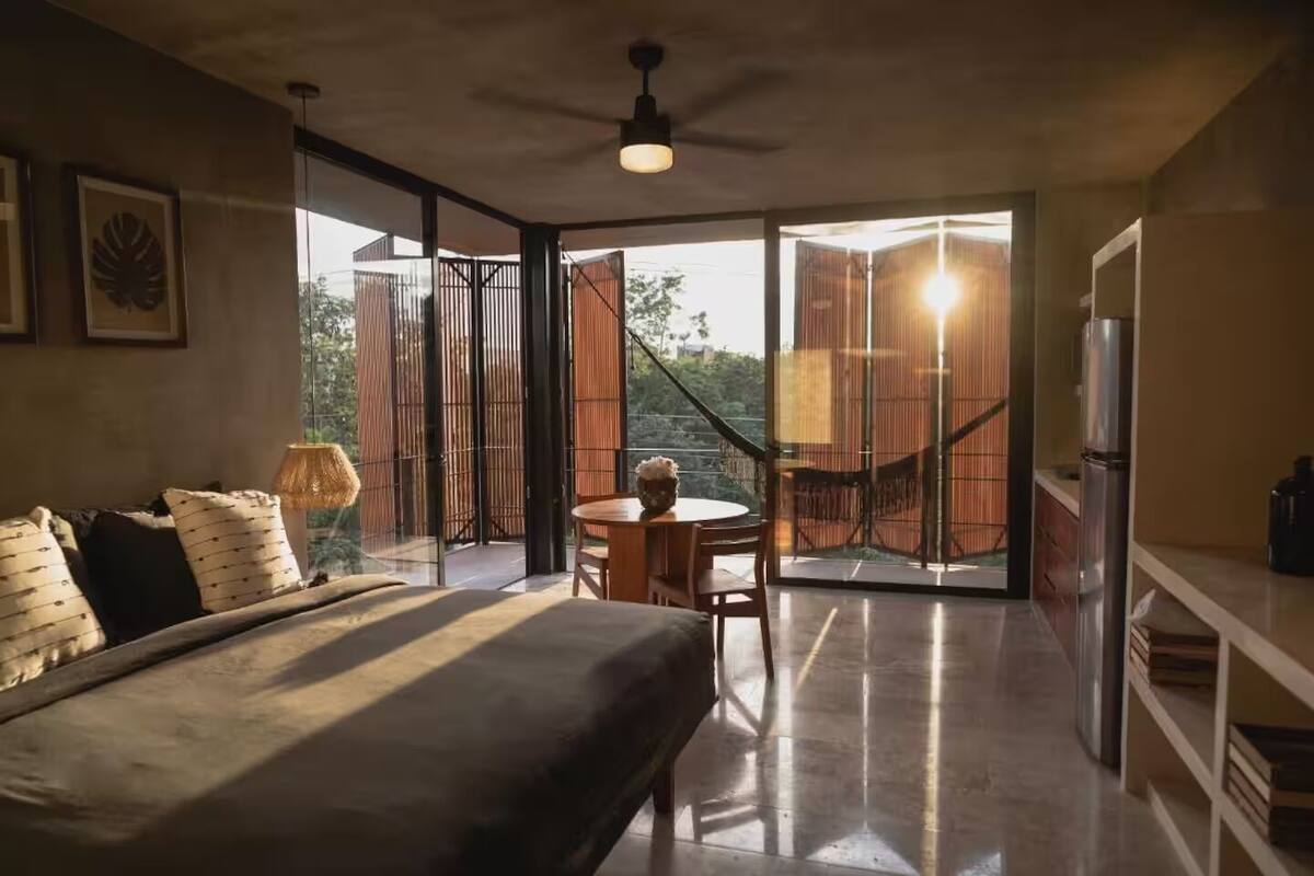 Une chambre moderne avec un grand lit, une table à manger et un balcon offrant une vue agréable.