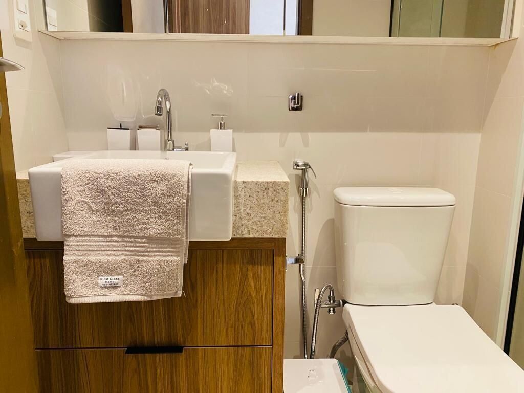 A modern bathroom with a sink, mirror, and toilet.