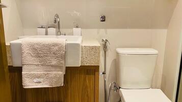 A modern bathroom with a sink, mirror, and toilet.