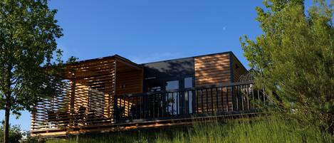 A modern building with a wooden exterior, a balcony, and a staircase.