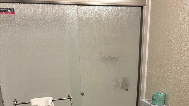 A bathroom with a shower, toilet, and vanity. - Baymont By Wyndham Bridgeton St Louis (Bridgeton)