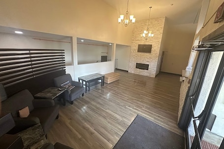 A spacious living area with a sofa, coffee table, and a fireplace.