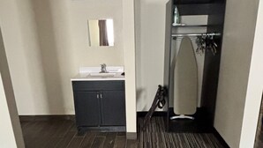 Un baño de hotel con lavabo, espejo y ducha.
