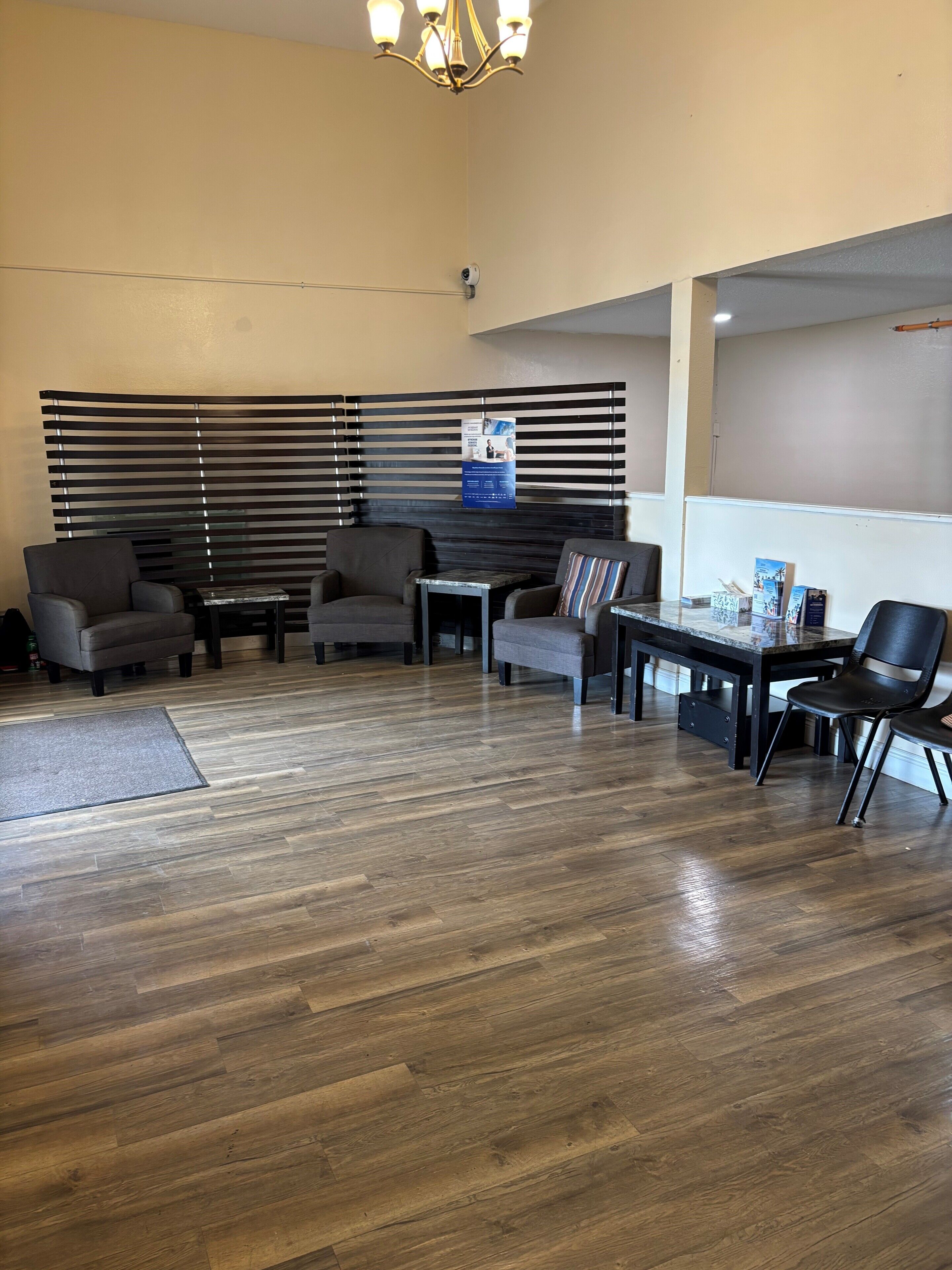 A lobby with a seating area, a reception desk, and a chandelier.