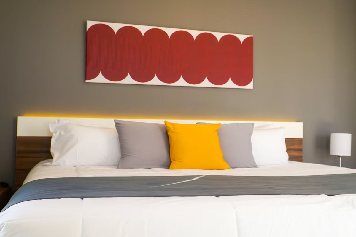A bed with a headboard, pillows, and a blanket.