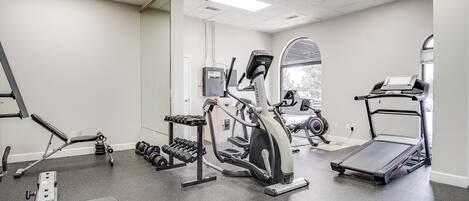 Un gimnasio con cintas de correr, elípticas y pesas sueltas.