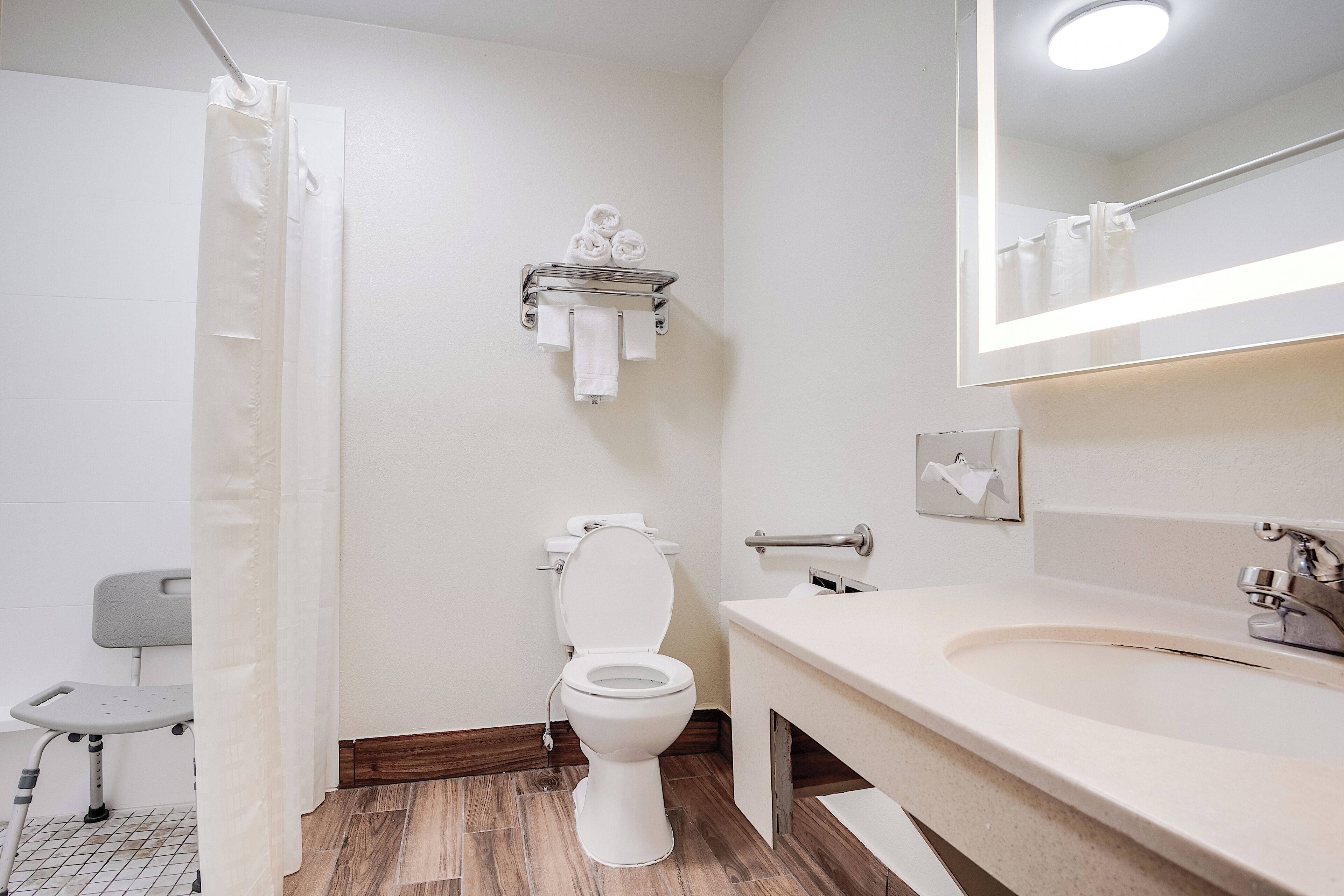 A bathroom with a toilet, sink, and shower curtain.
