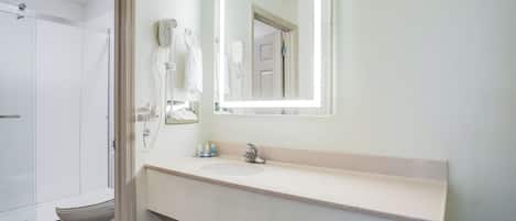 A bathroom with a sink, mirror, and hairdryer.