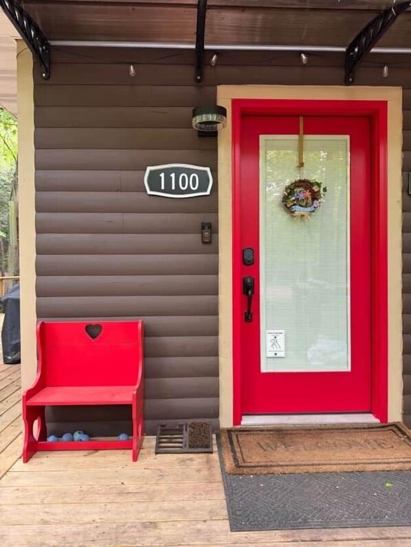 A red door with a number sign, a bench, and a wreath on the door. - 100-Acre Luxury, Dog-Friendly, Sleeps 8-10 (Denver Township)