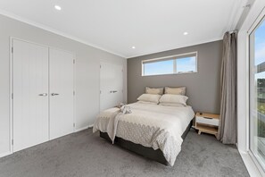 A bedroom with a bed, a window, a wardrobe, and a nightstand. - Parekaawa Playhouse - Motuoapa Holiday Home (Motuoapa)