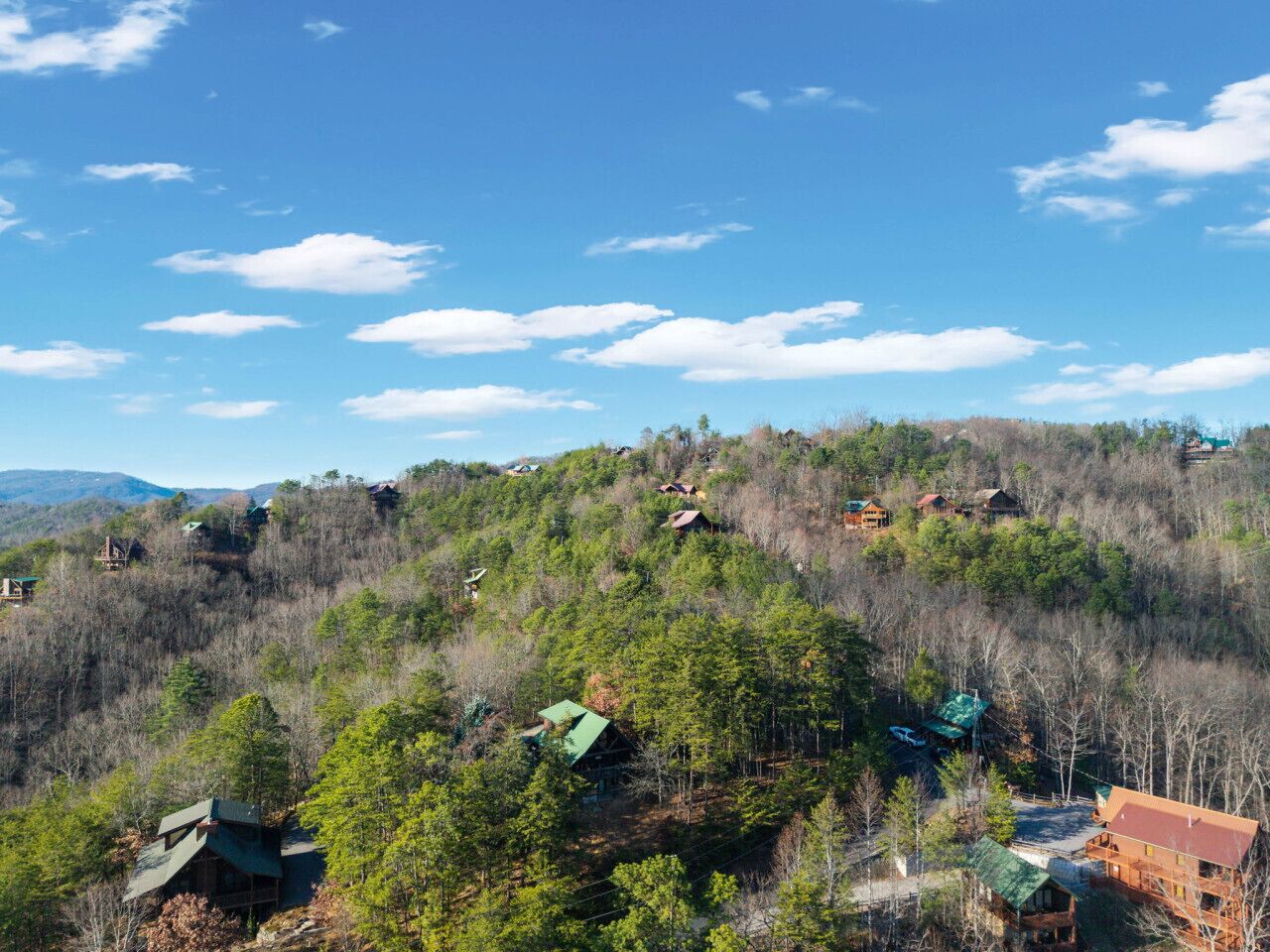 Uma região montanhosa com várias cabanas e casas aninhadas em densas florestas.