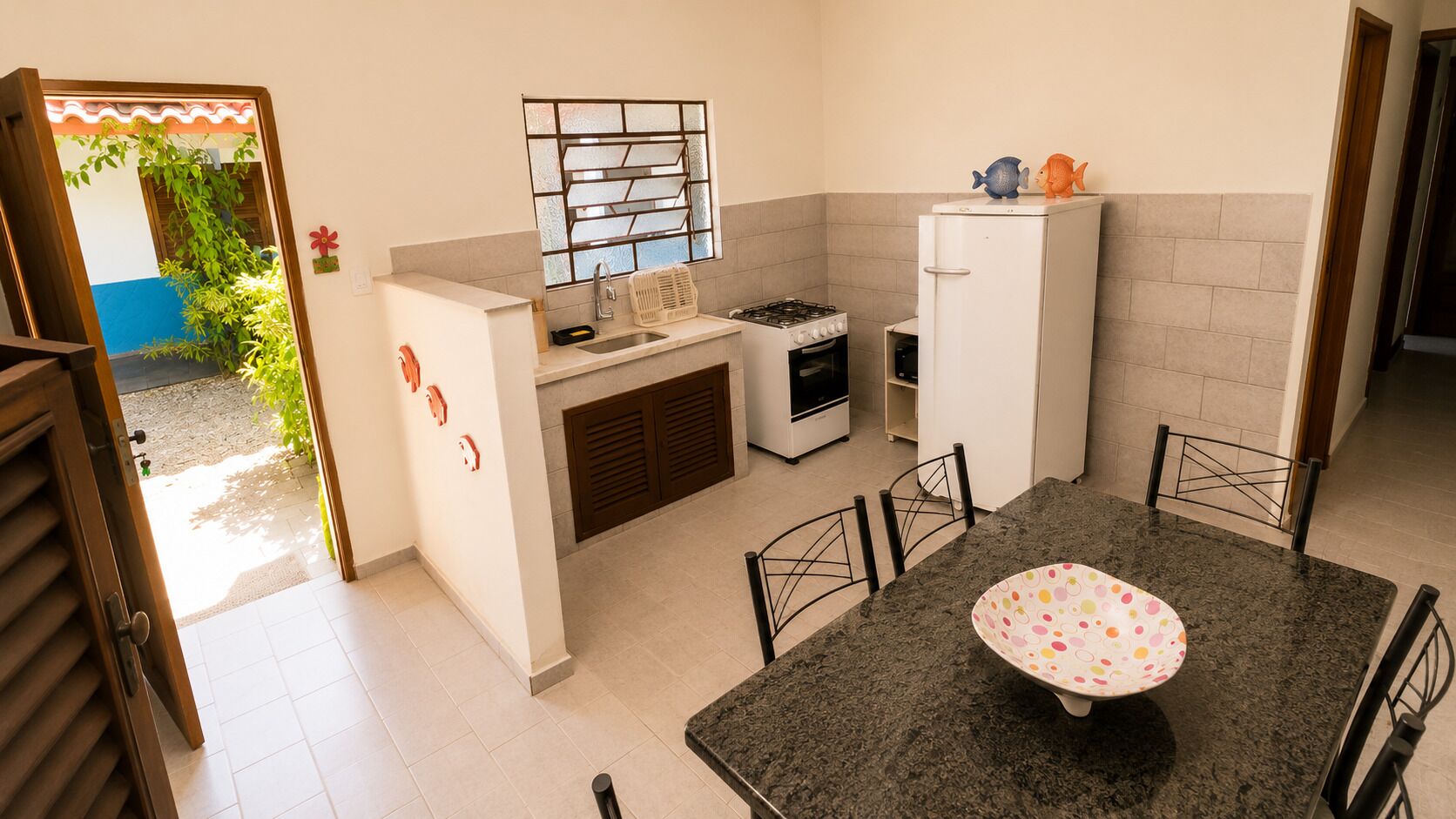 A compact kitchen with a dining area, a gas stove, a refrigerator, and a small oven.