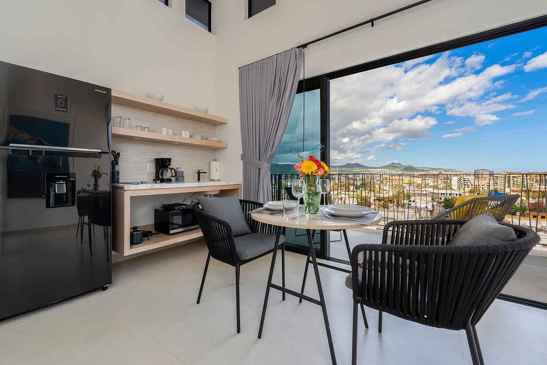 Een moderne keuken met een inbouwkoelkast en een eethoek met een tafel en stoelen.