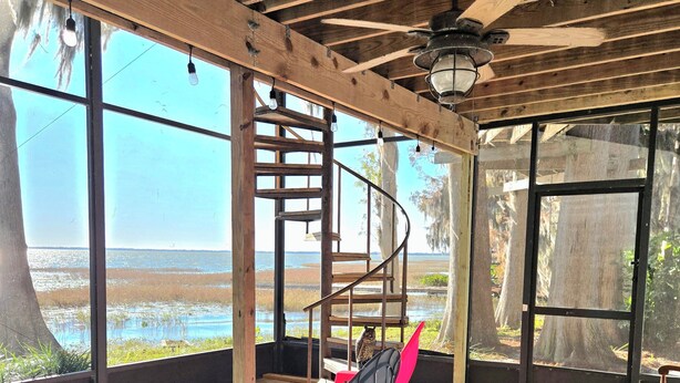 A covered outdoor seating area with a wooden ceiling, a spiral staircase, and a view of the beach. - Lake Eustis Waterfront Sunset House 3/2 Amazing Views! Boat Dock Available!  (Eustis)