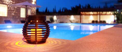 A poolside area with a decorative lantern and a building in the background.