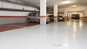 Un estacionamiento subterráneo de varios niveles con automóviles estacionados en espacios designados.