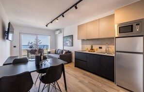 A modern kitchen with a large island, stainless steel appliances, and a view to the sea. - Nice apartment in Potomje with swimming pool (Potomje)