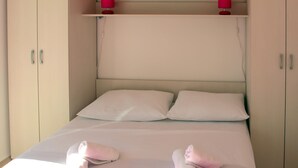 A bed with two pillows, a bedside table with a lamp, and a wardrobe with a mirror. - 1 bedroom awesome apartment in Klek (Klek)