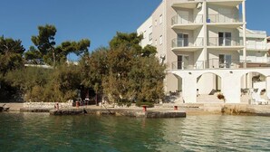 Un edificio de varios pisos con balcones, cerca de una masa de agua.