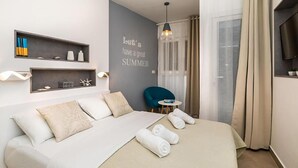 Una habitación de hotel moderna con cama, una mesita, una silla y una pared con una cita motivacional.