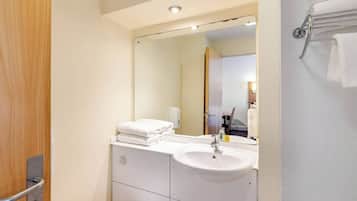 A modern bathroom with a white sink, mirror, and towel rack.