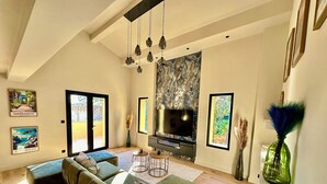 A modern living room with a sectional sofa, a flat-screen TV, and artwork on the walls. - 🔥 NEW FOR RENT - Premium Villa with Pool & Games - 10 pers (Fréjus)