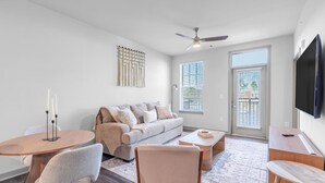Ein modernes Wohnzimmer mit Sofa, Couchtisch und Fernseher.