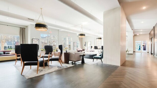 Eine großzügige Hotelhalle mit moderner Einrichtung, großen Fenstern und einer gewölbten Decke.