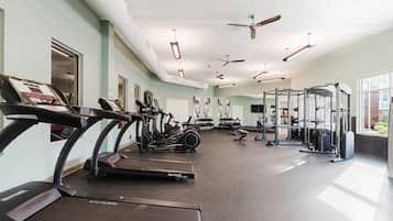 A gym with treadmills, stationary bikes, and weightlifting equipment.