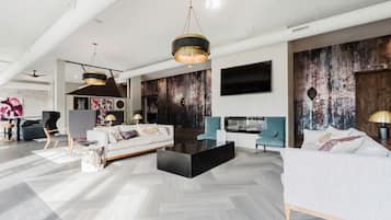 Un salon moderne avec un canapé, une table basse et deux fauteuils.