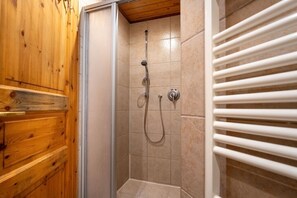A shower with a glass door, a towel rack, and wooden paneling. - Binzer Waldhof - Haus Fuchsbau (Binz)