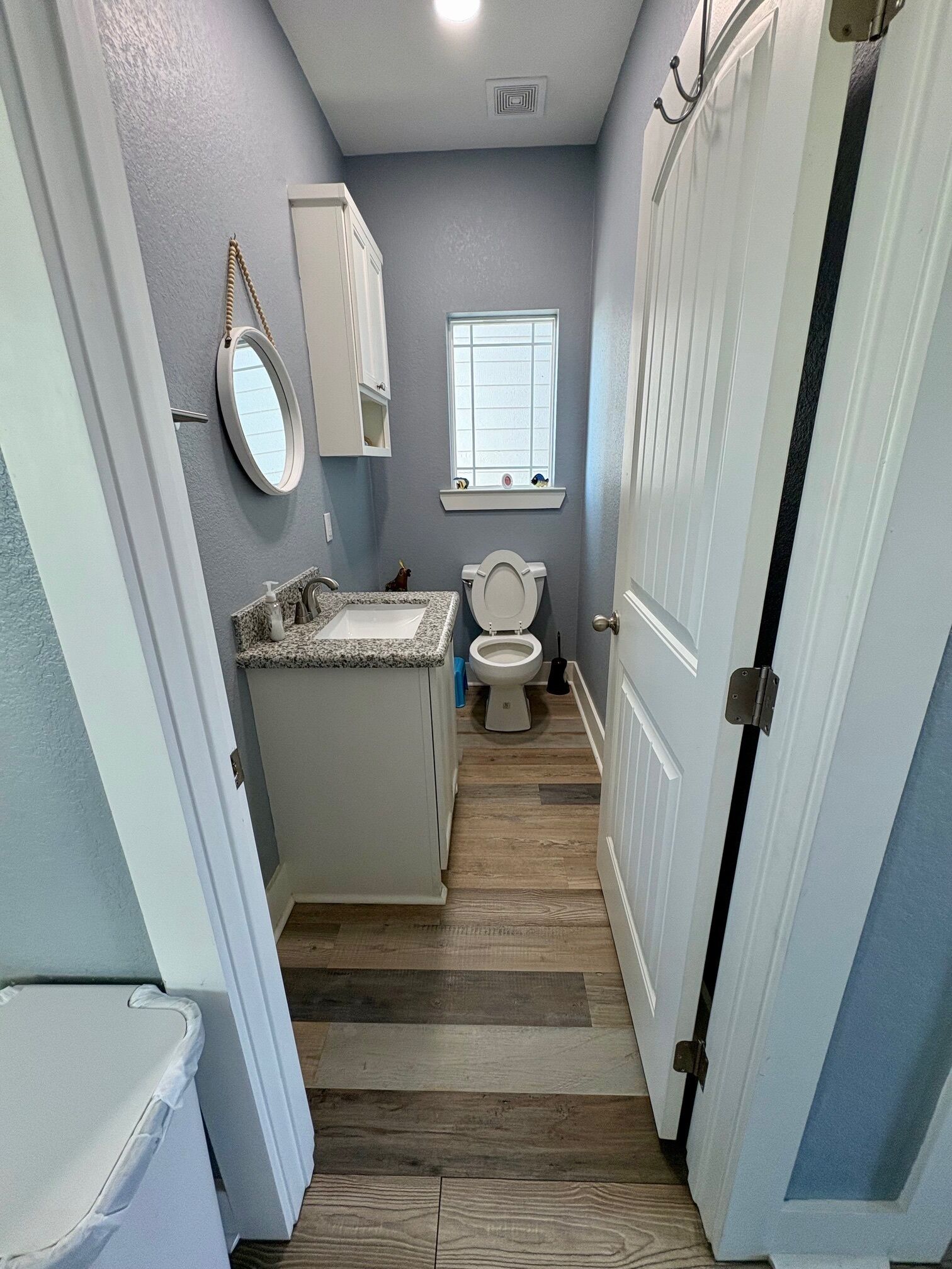 Une petite salle de bain comprenant un meuble-lavabo, des toilettes et une fenêtre.