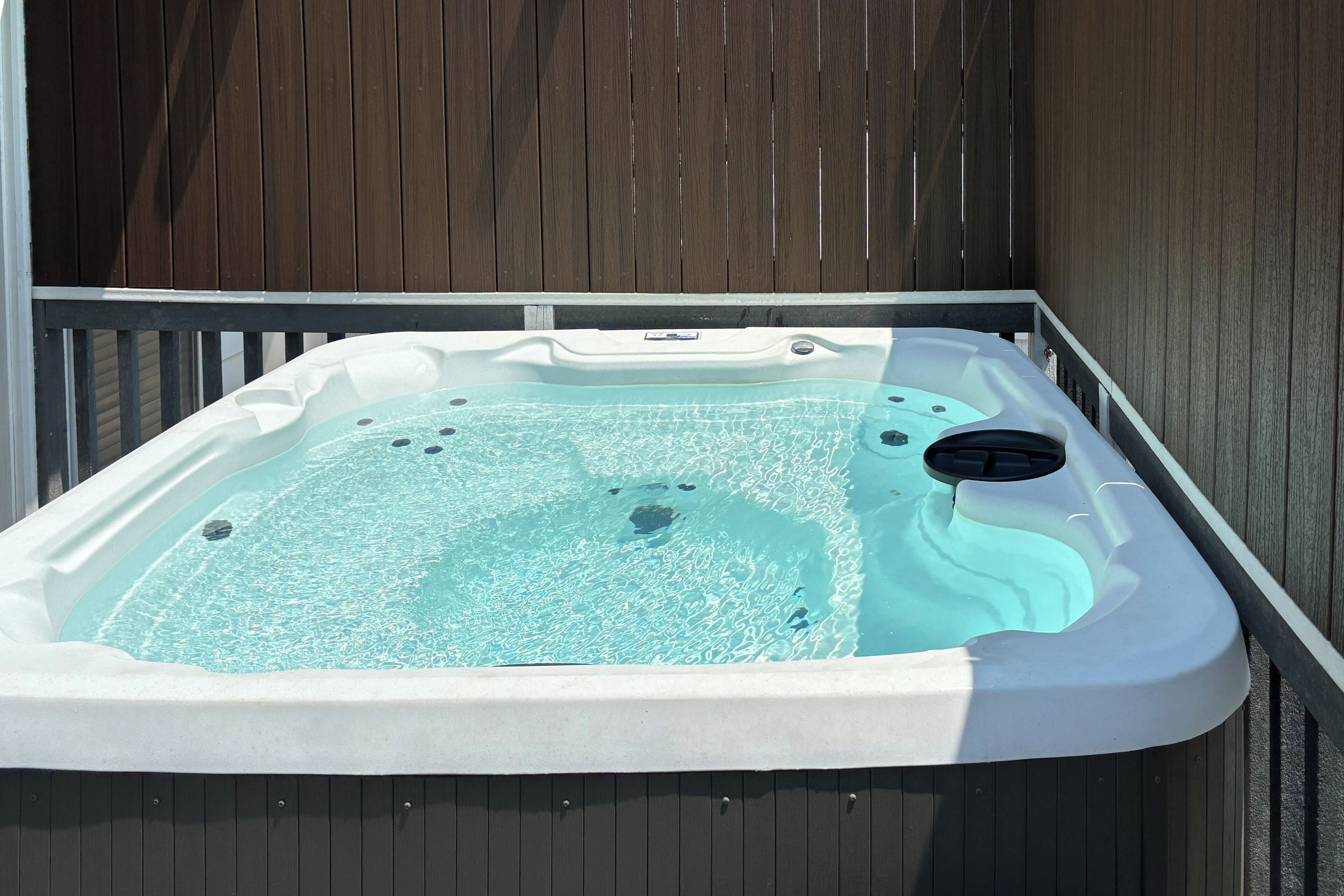 A hot tub with a wooden deck surrounding it.