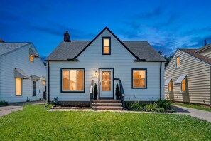 A two-story house with a front porch, a visible number '5252' on the door, and a well-maintained lawn.
