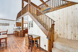 Un escalier en bois offrant une vue sur la cuisine et la salle à manger.