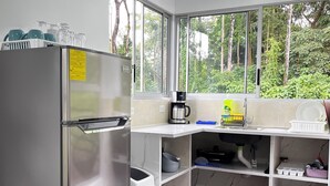 A modern kitchen with a stainless steel refrigerator, a coffee maker, and a sink. - Toucan House (Valle Azul)