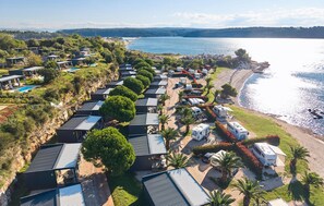 A coastal RV park with multiple RVs and mobile homes, surrounded by greenery and a beach. - Stunning home in Novigrad with swimming pool (Novigrad)