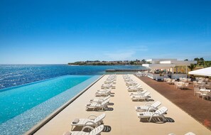 A poolside area with lounge chairs and a bar, overlooking a clear blue sea. - Stunning home in Novigrad with swimming pool (Novigrad)