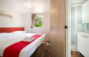 A hotel room with a bed, a window with curtains, a bathroom with a sink, and a wooden floor. - Awesome home in Novigrad with swimming pool (Novigrad)
