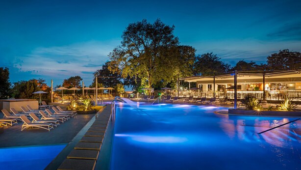 Ein Poolbereich mit Liegestühlen und einer Bar.