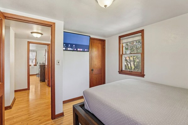 A bedroom with a bed, a window, and a TV on the wall. - Church Street Retreat - Downtown Location! (Wisconsin Dells)